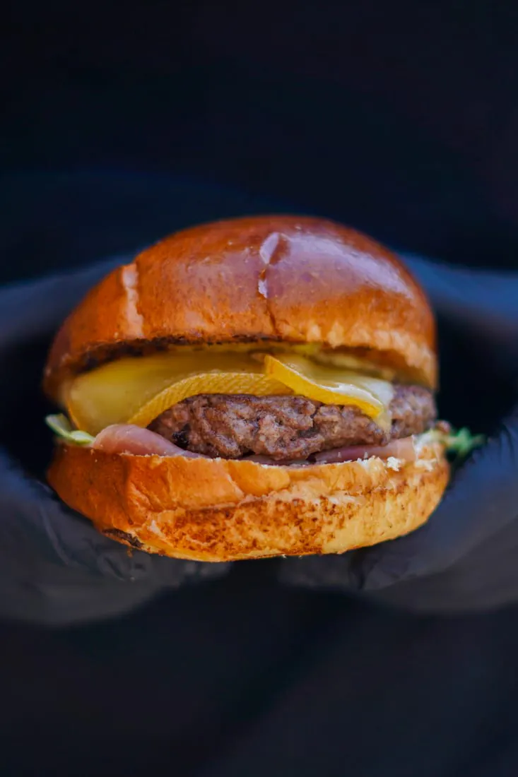 Burger maison du Retro, steak haché saisi, fromage fondu et pain brioché doré