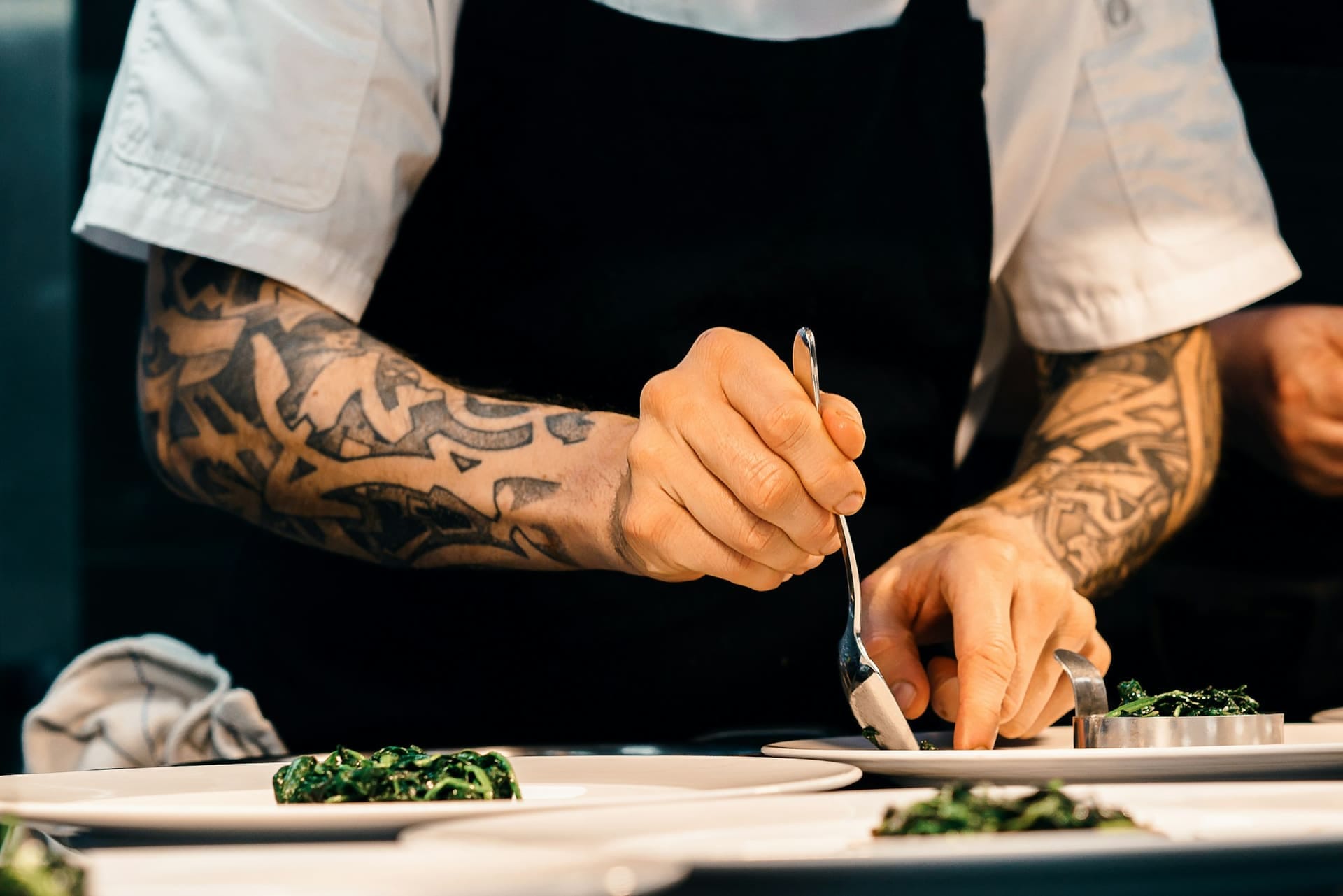Chef dressant des assiettes de légumes en cuisine