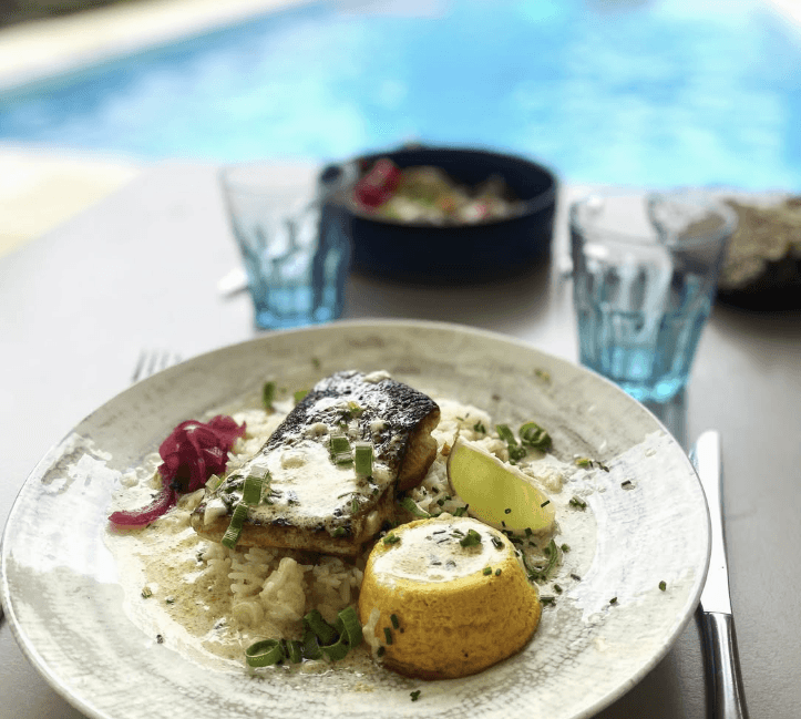 Poisson grillé sur risotto crémeux servi en terrasse