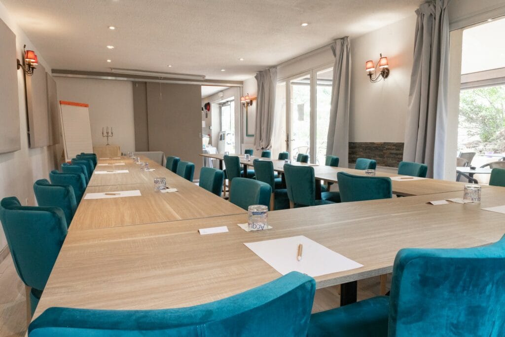 Salle de séminaire en configuration en U avec chaises en velours bleu-vert