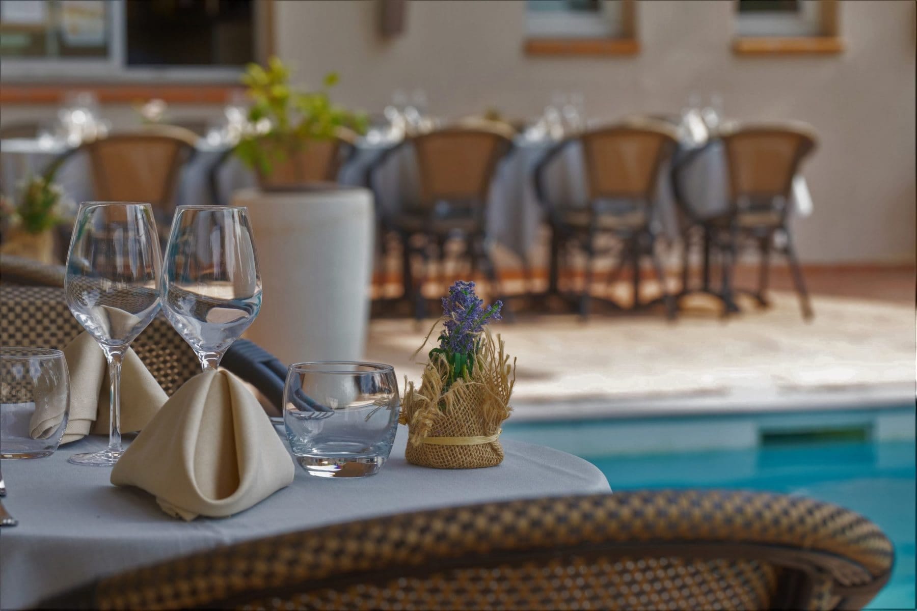 Table dressée en terrasse au bord de la piscine du domaine La Garrigue, au Pôle d'Activités d'Aix-en-Provence