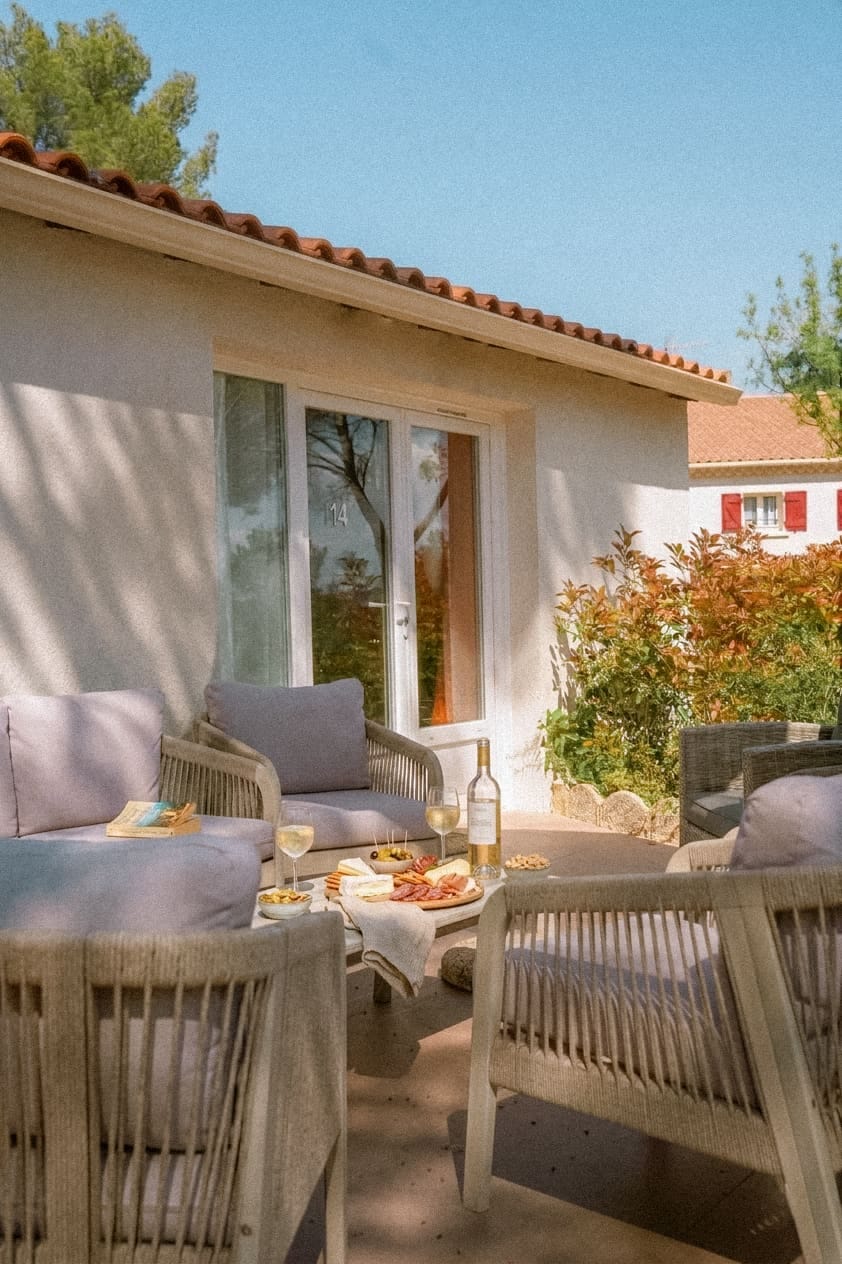Terrasse d'un hébergement du domaine avec salon de jardin et plateau de charcuterie