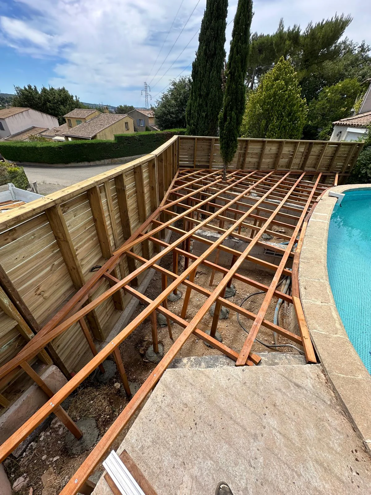 Structure en bois en cours de construction autour de la piscine