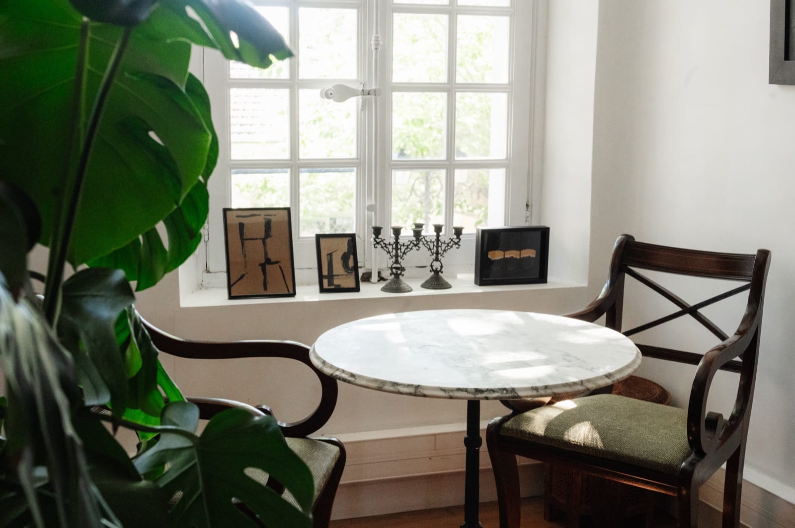 Marble table, antique chairs and artworks set in the window