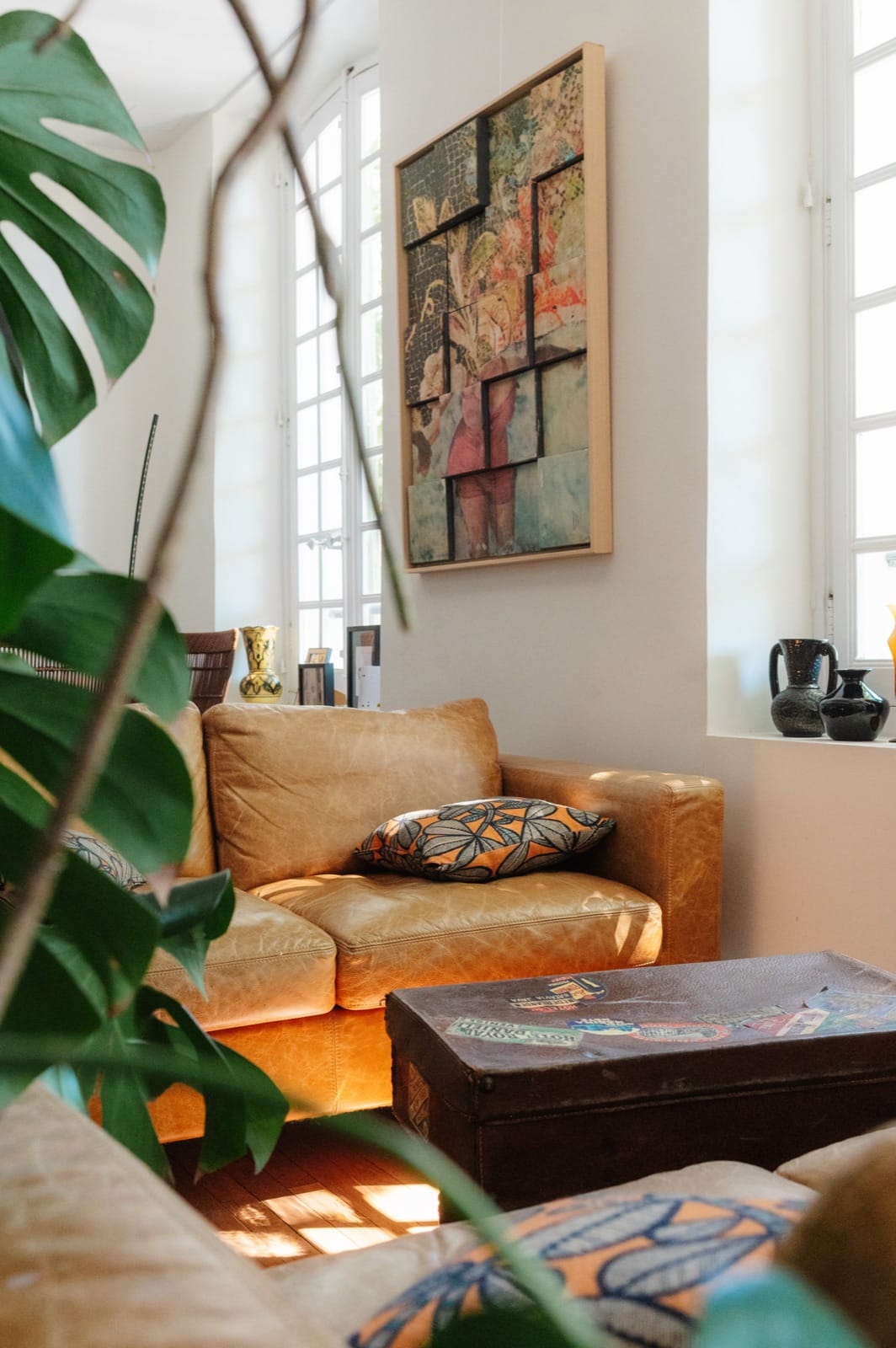 The lounge: leather sofa beneath a large exhibited artwork