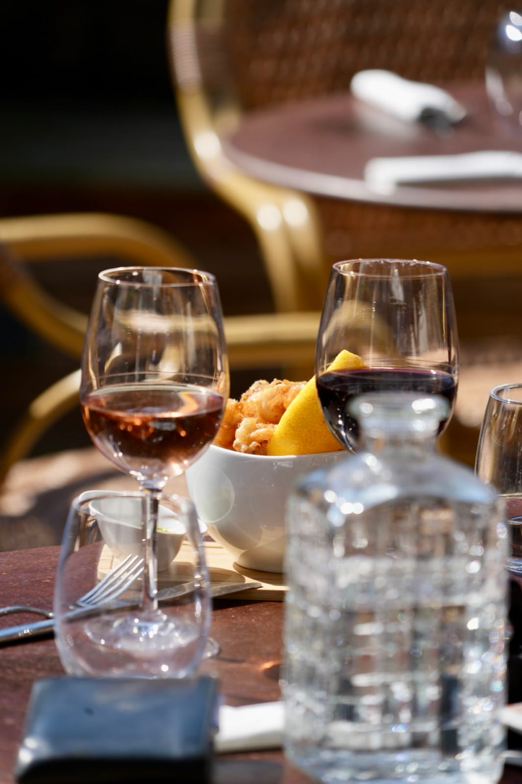 Aperitif time: glasses of wine, a carafe and fritters to share