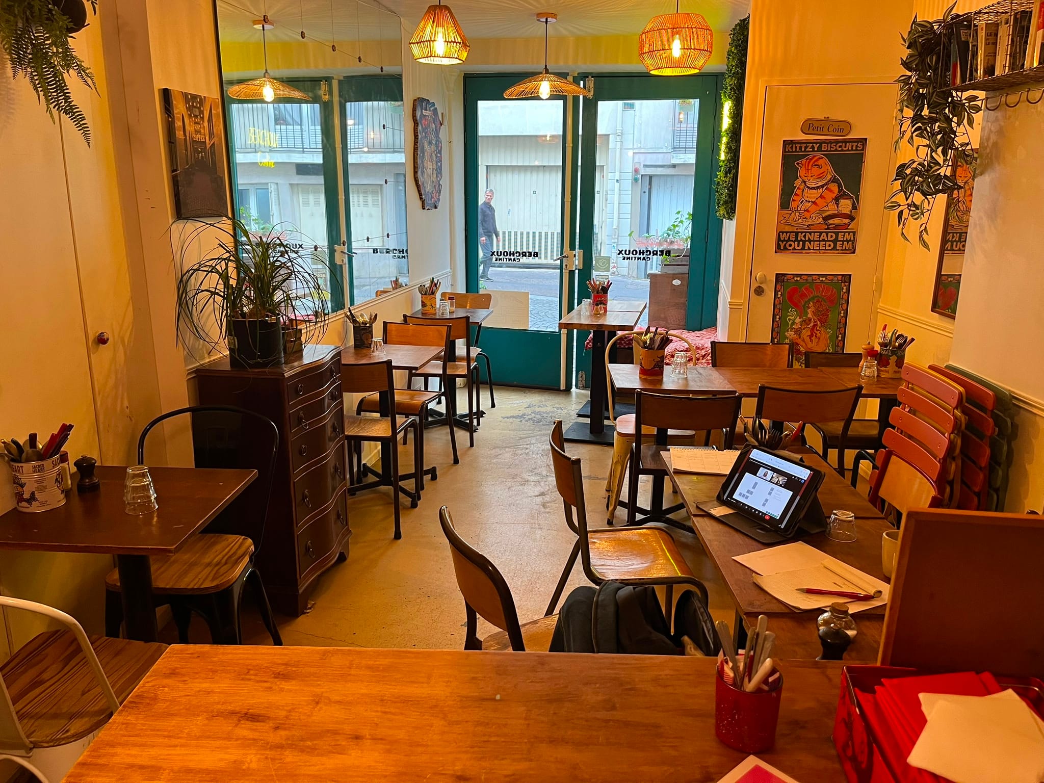 Intérieur Berchoux : tables en bois et néon vert acide BERCHOUX au mur