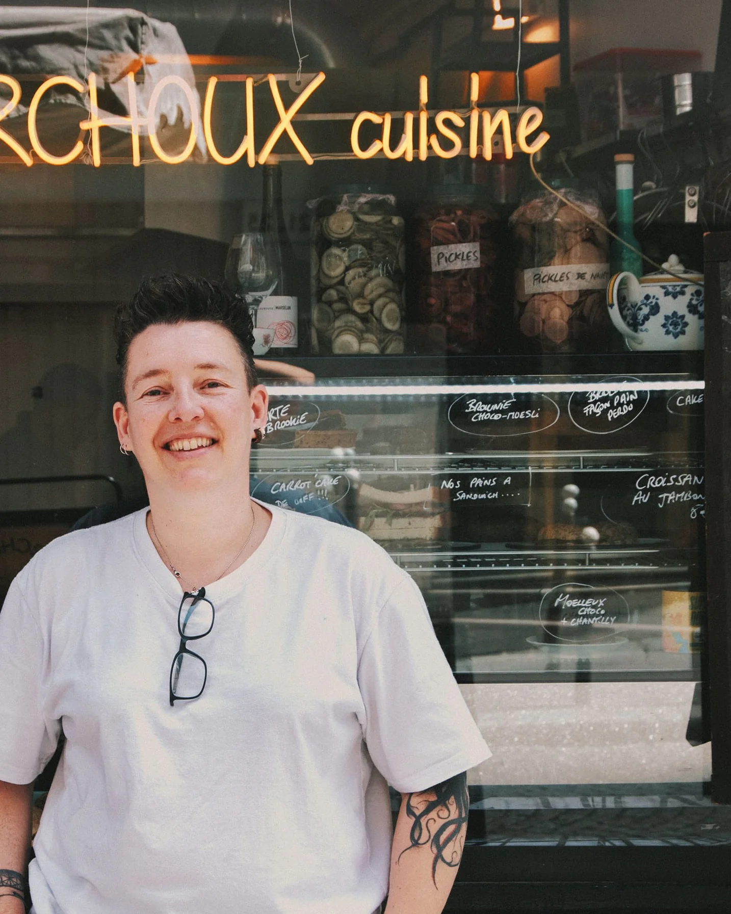 Julie Berchoux, cheffe, souriante devant la vitrine de son restaurant de cuisine maison à Montmartre