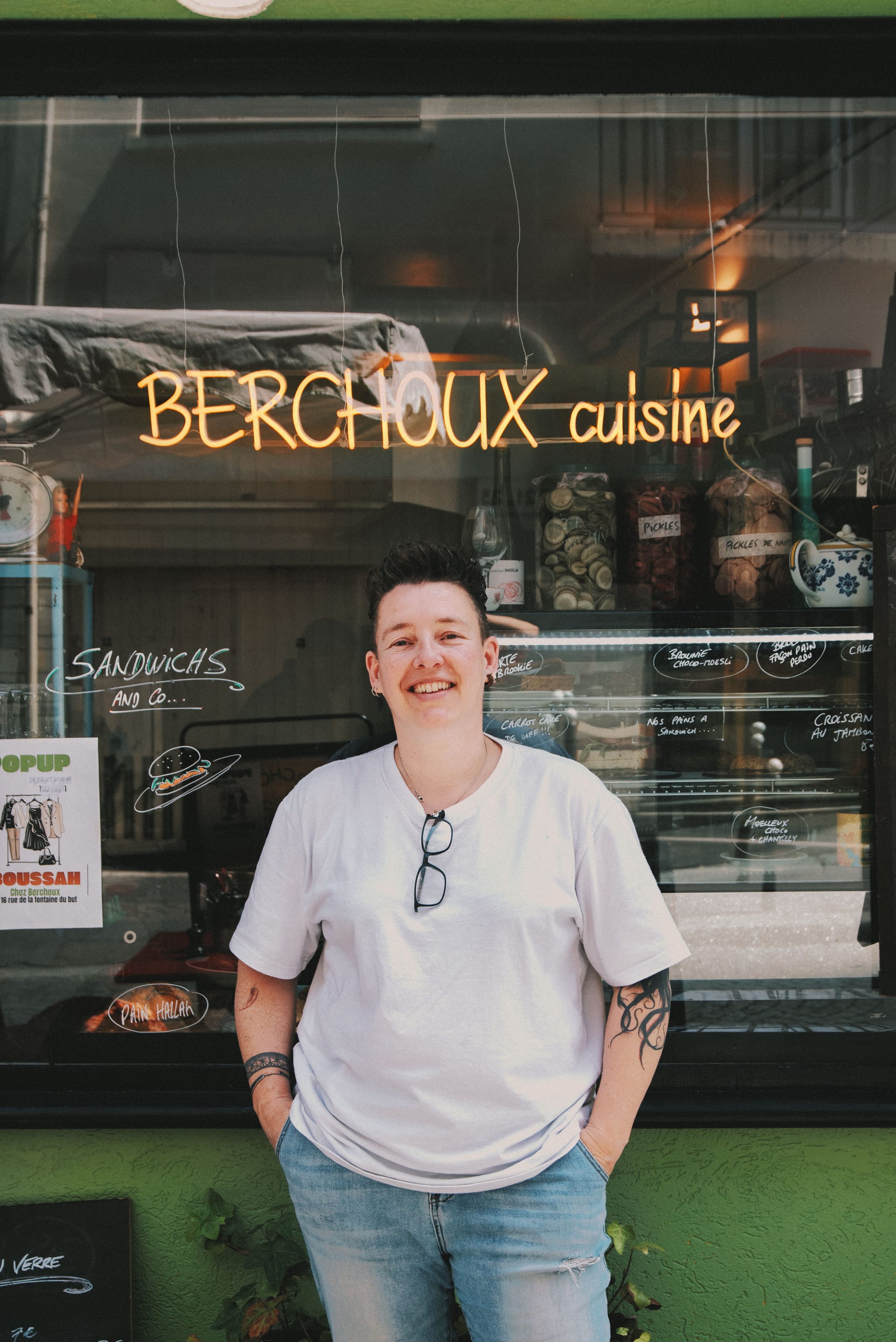 Julie Berchoux devant la devanture de son restaurant rue de la Fontaine du But, sous le néon BERCHOUX cuisine