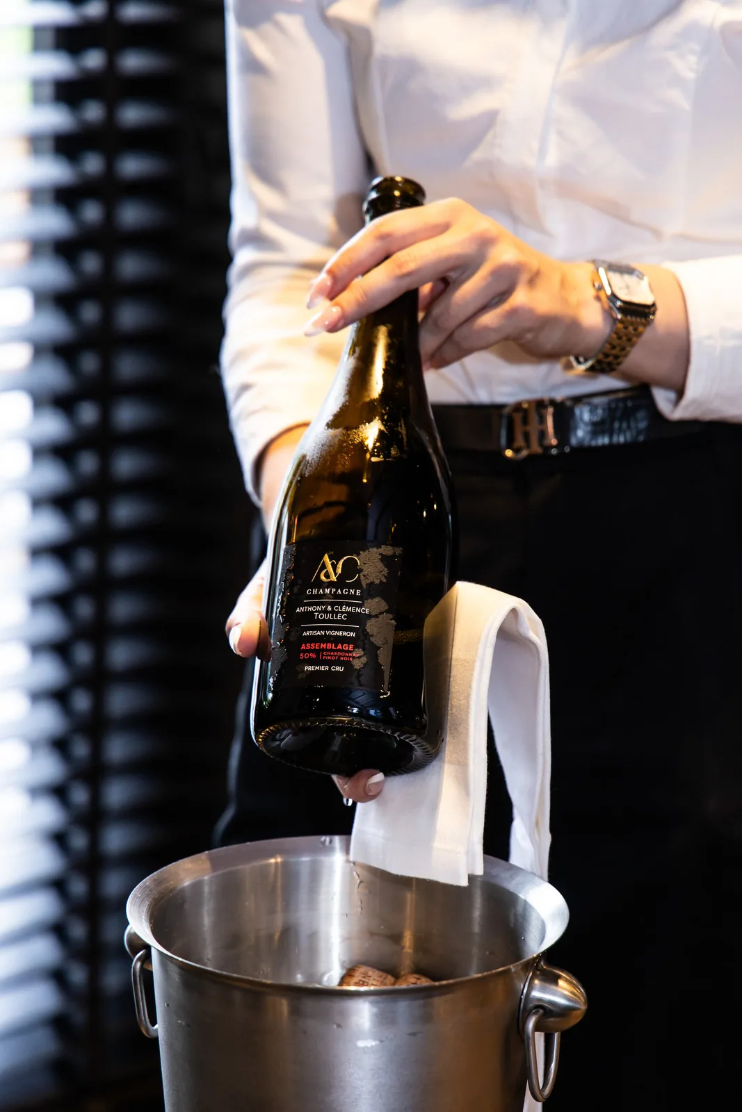 Le sommelier ouvre une bouteille au-dessus du seau à glace