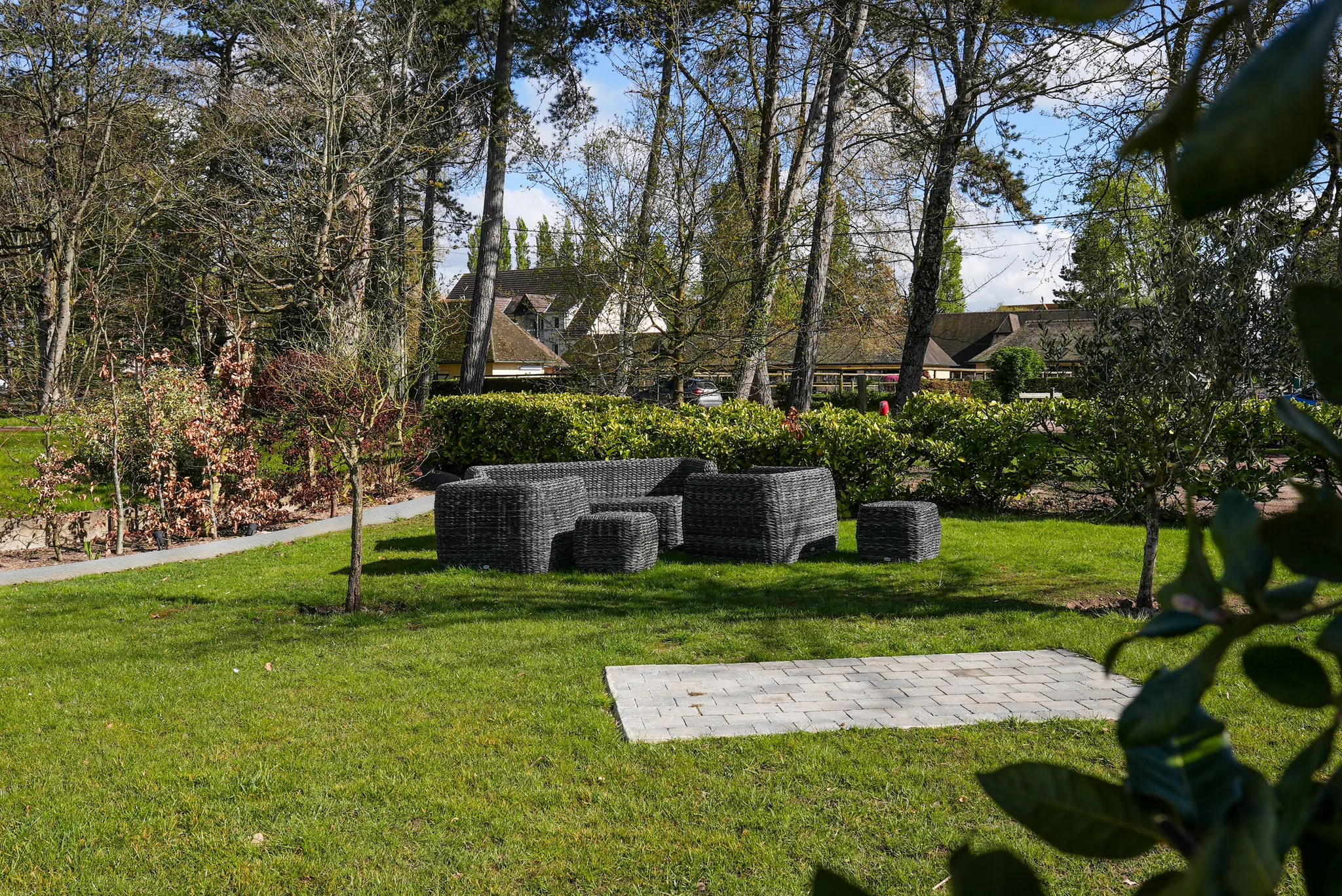 Le salon du jardin, fauteuils et tables basses sous les arbres