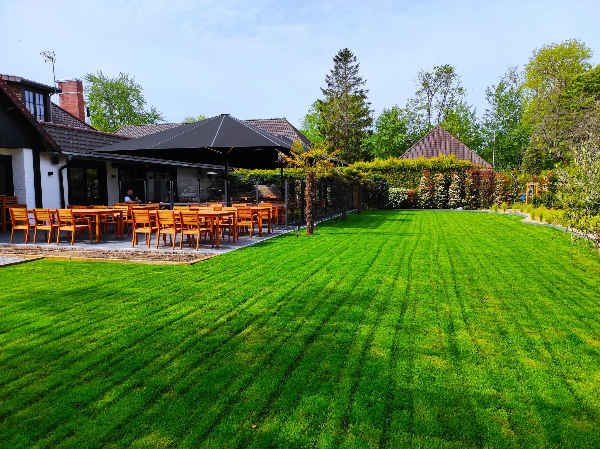 La pelouse du jardin et la terrasse, en plein jour