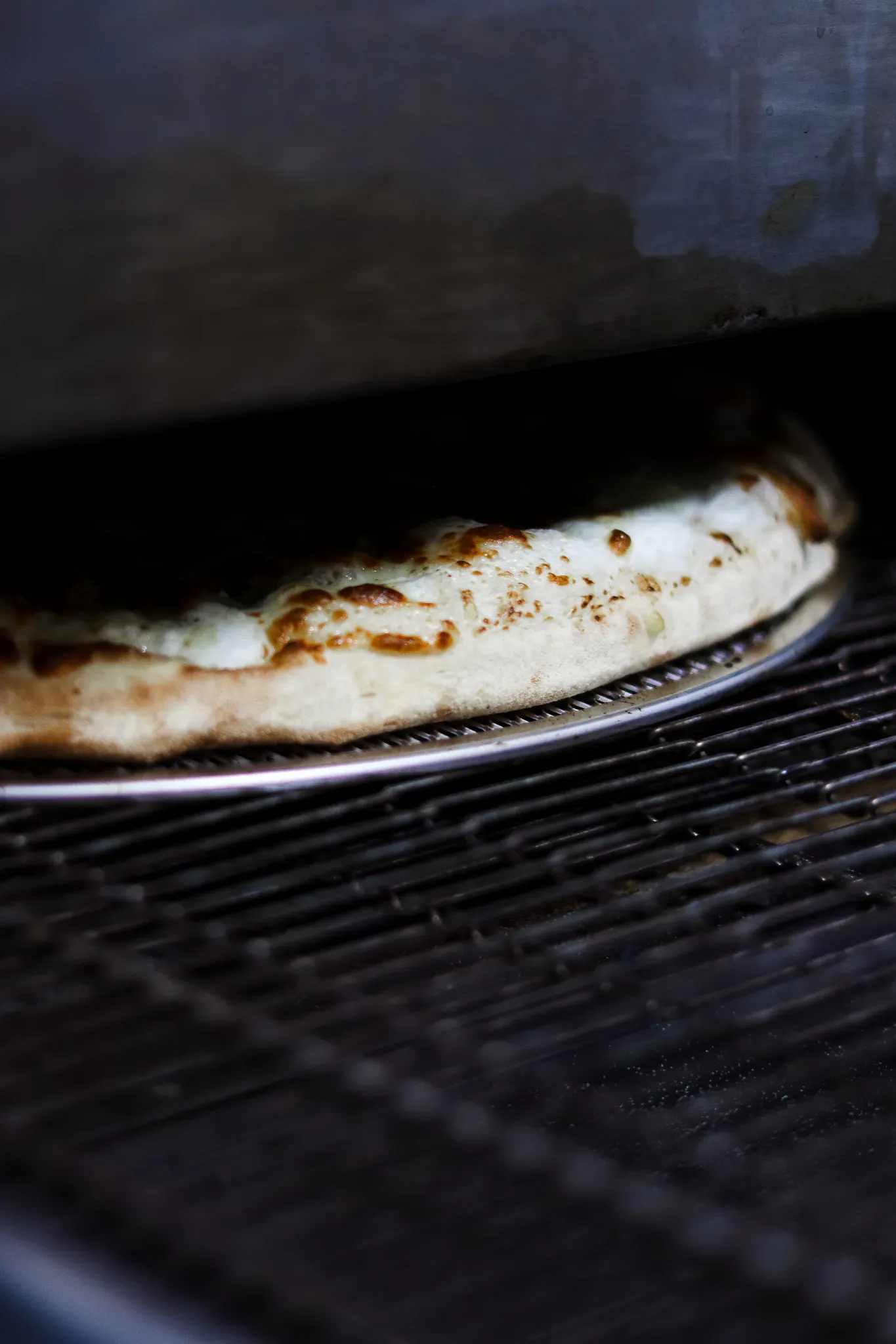 Pizza a la mozzarella en cours de cuisson dans le four de Pizza Crush