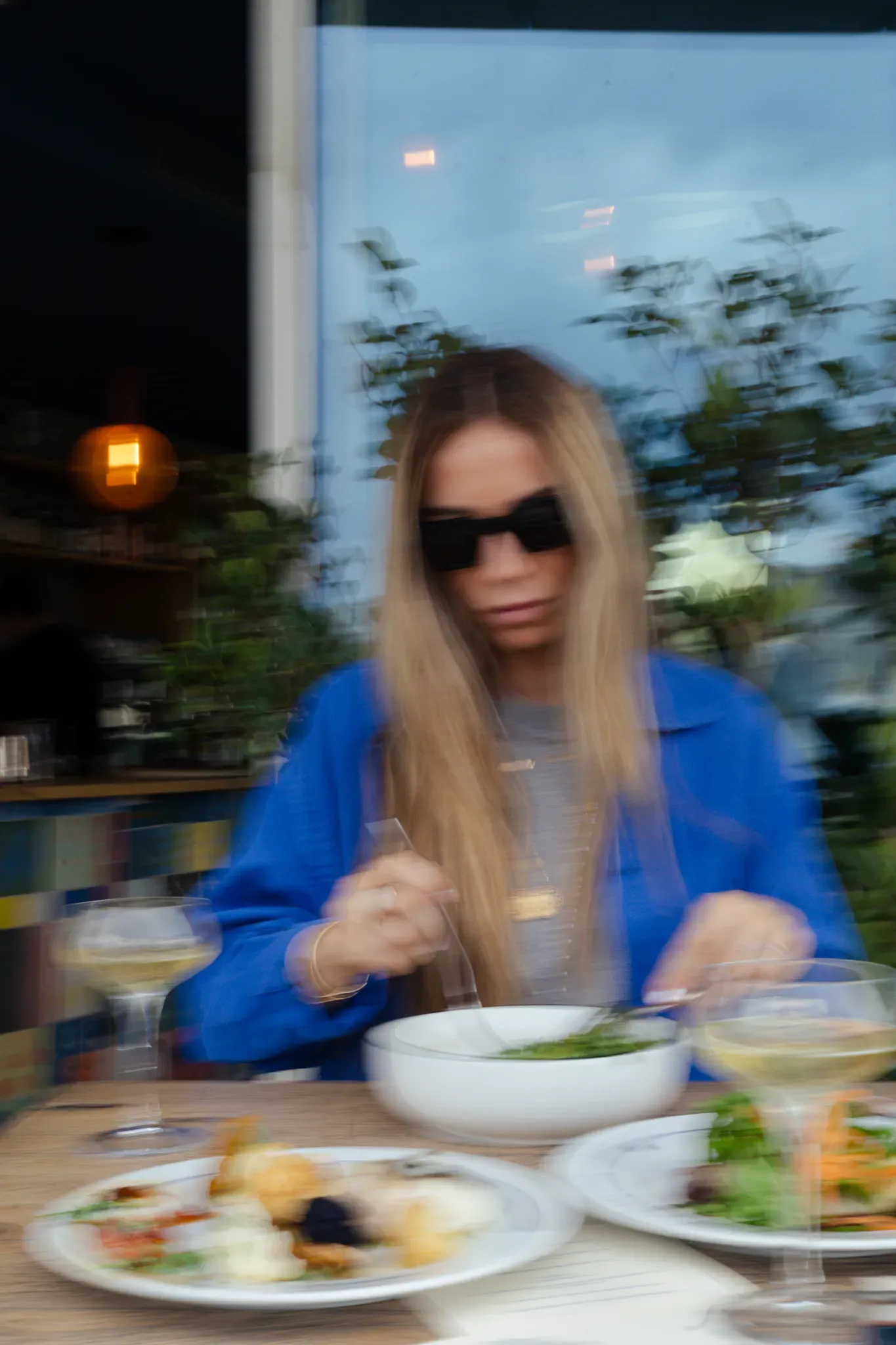Déjeuner en terrasse, assiettes et verre de vin blanc
