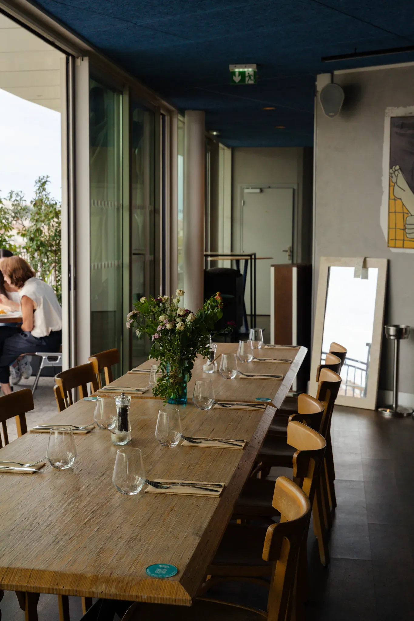 Longue table dressée avec un bouquet de fleurs dans la salle intérieure