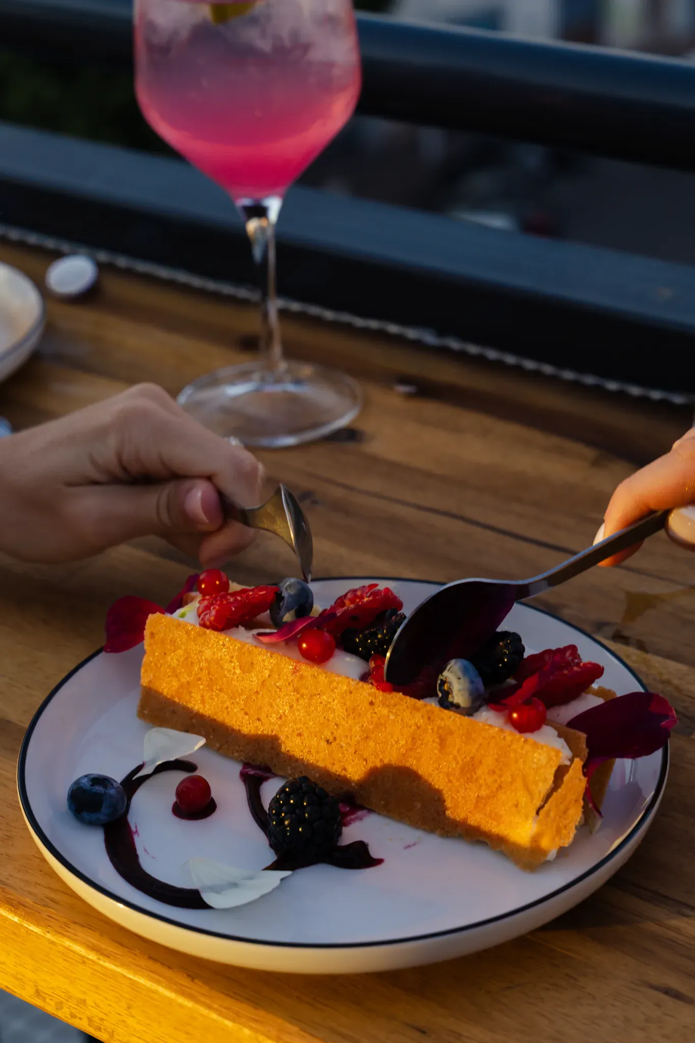 Dessert aux fruits rouges et cocktail rosé servis en terrasse