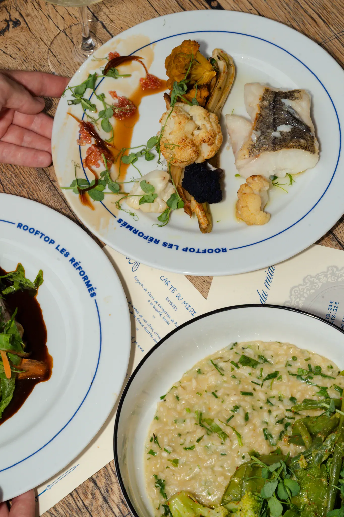 Poisson rôti et risotto verde dans la vaisselle du Rooftop les Réformés