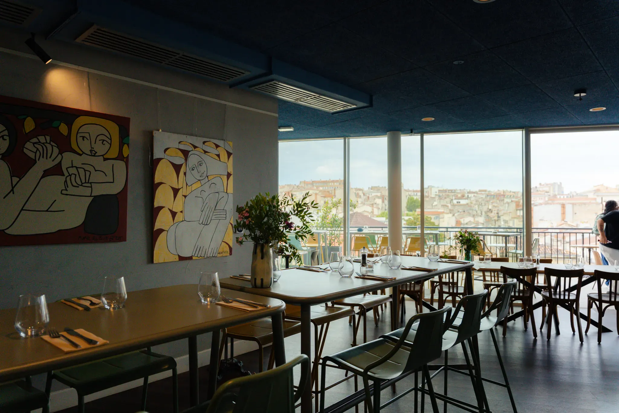Salle intérieure dressée, ouverte sur la ville par de grandes baies