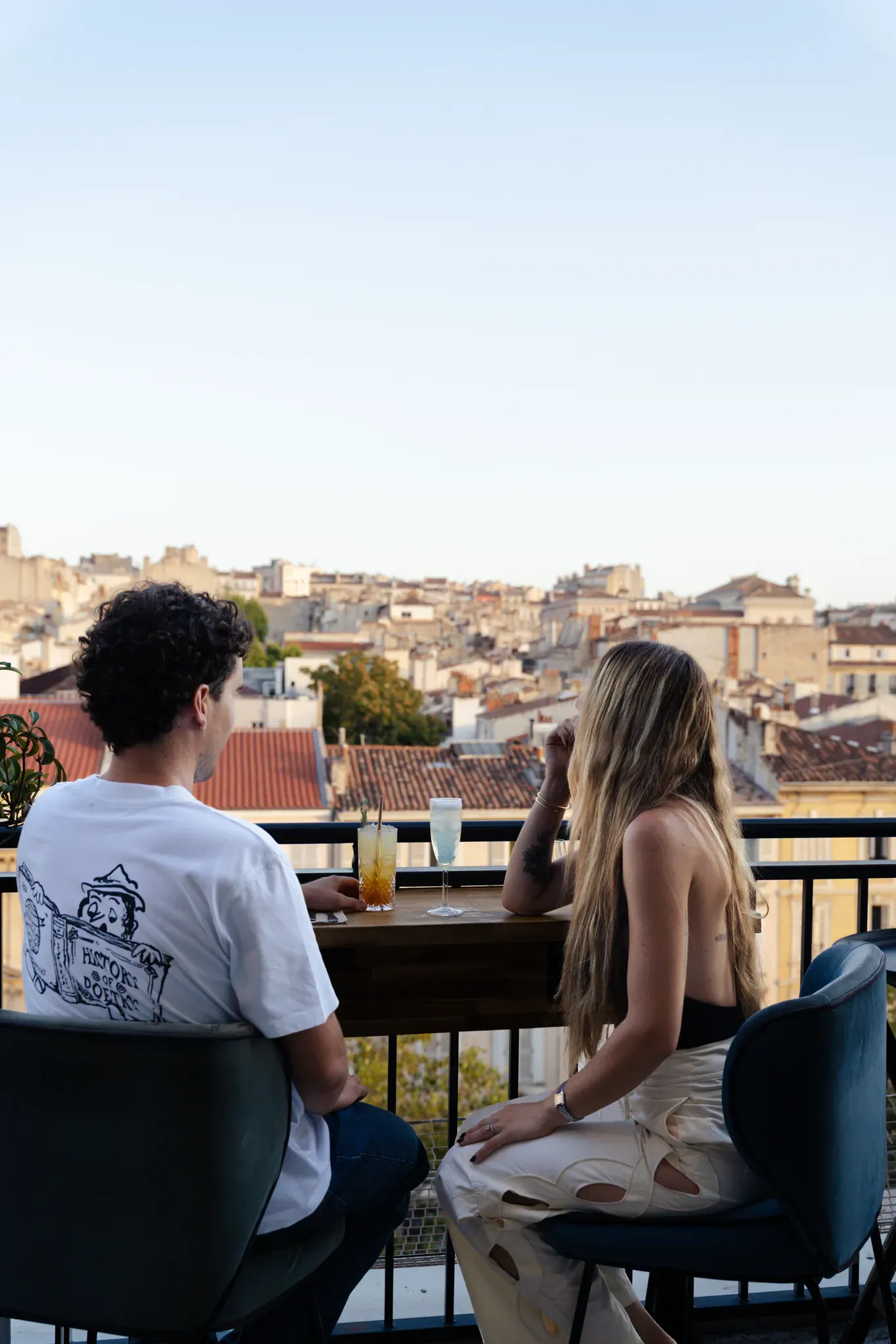 Couple attablé en terrasse face aux toits de Marseille