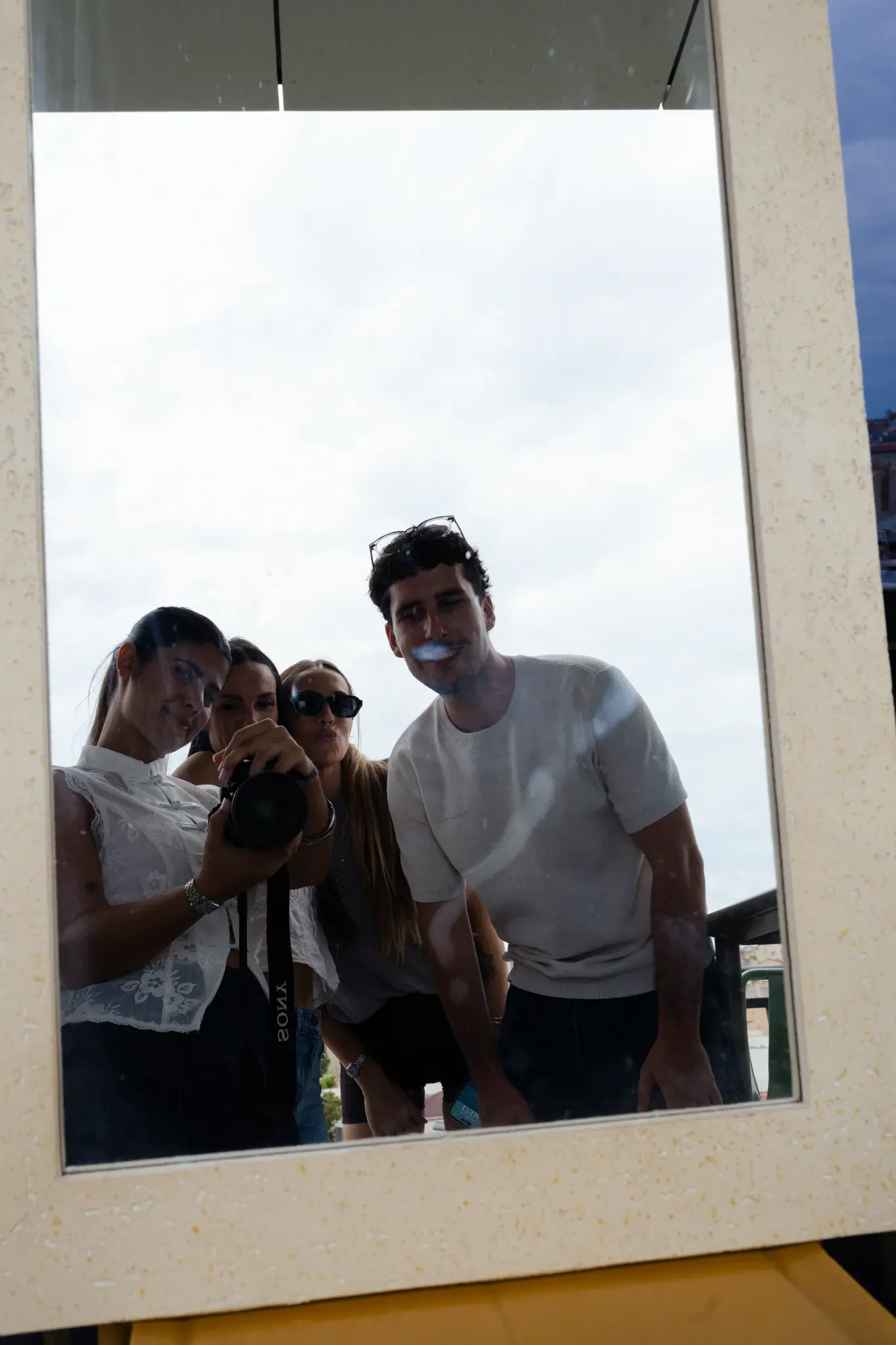Amis se photographiant dans le grand miroir de la terrasse