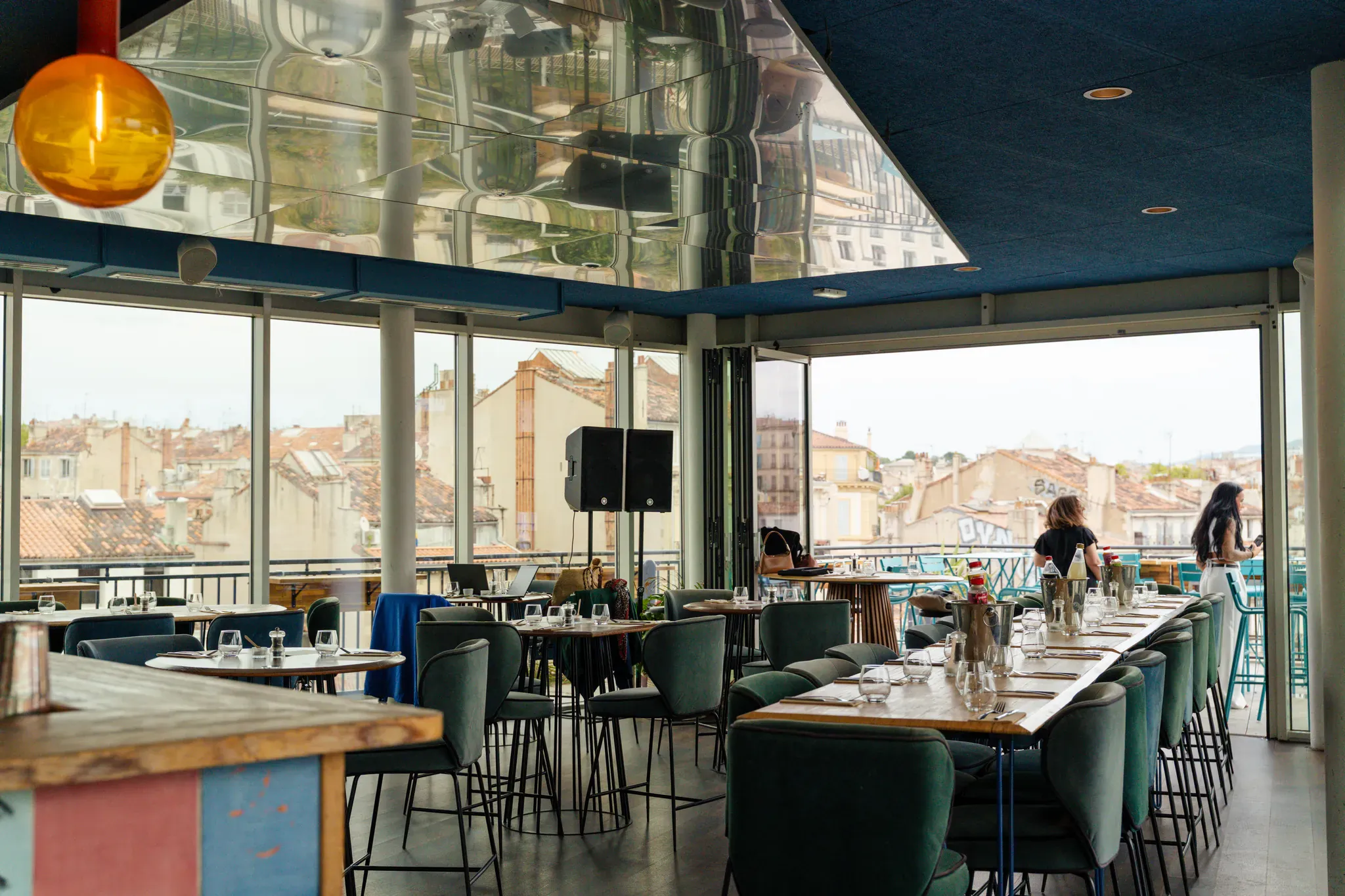 Salle panoramique et bar sous le plafond miroir, vue sur les toits