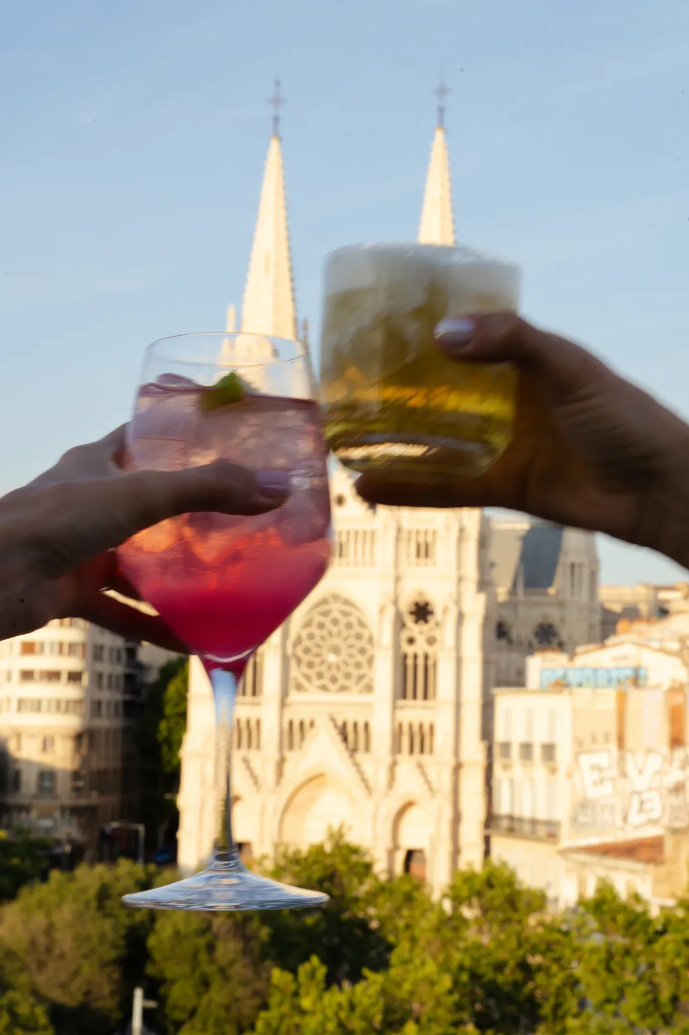 Deux verres trinqués en terrasse devant les clochers de l'église des Réformés