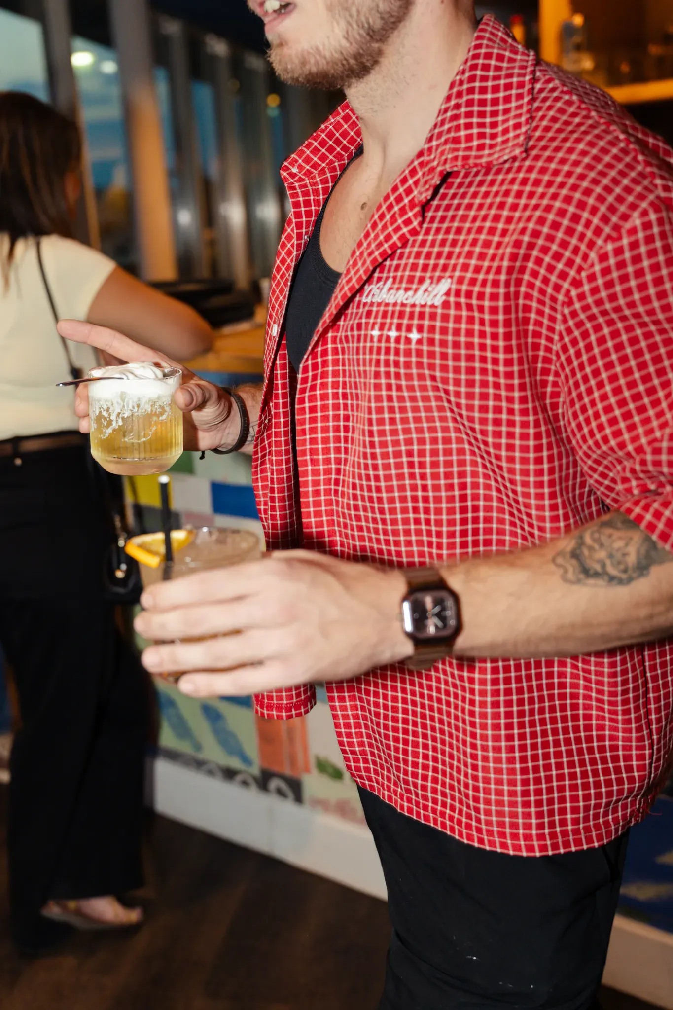 Cocktail à la main pendant une soirée au rooftop