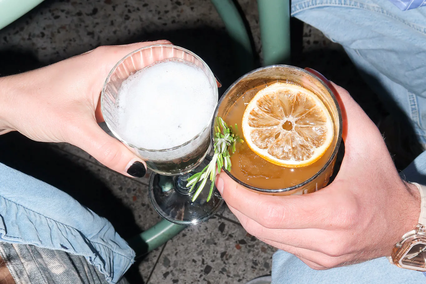 Deux cocktails garnis d'une tranche d'orange séchée, trinqués et vus du dessus