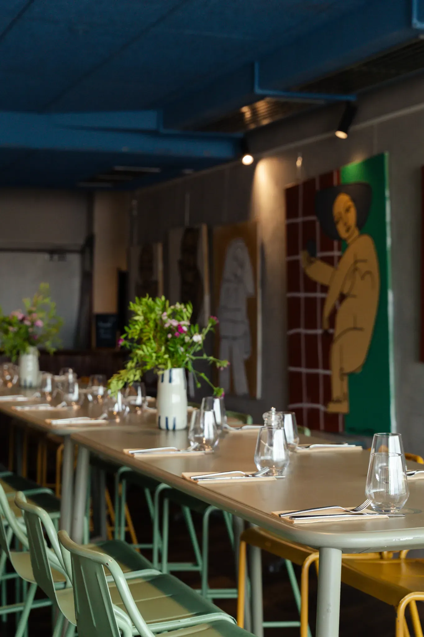 Salle intérieure dressée, tables hautes et œuvres d'art aux murs