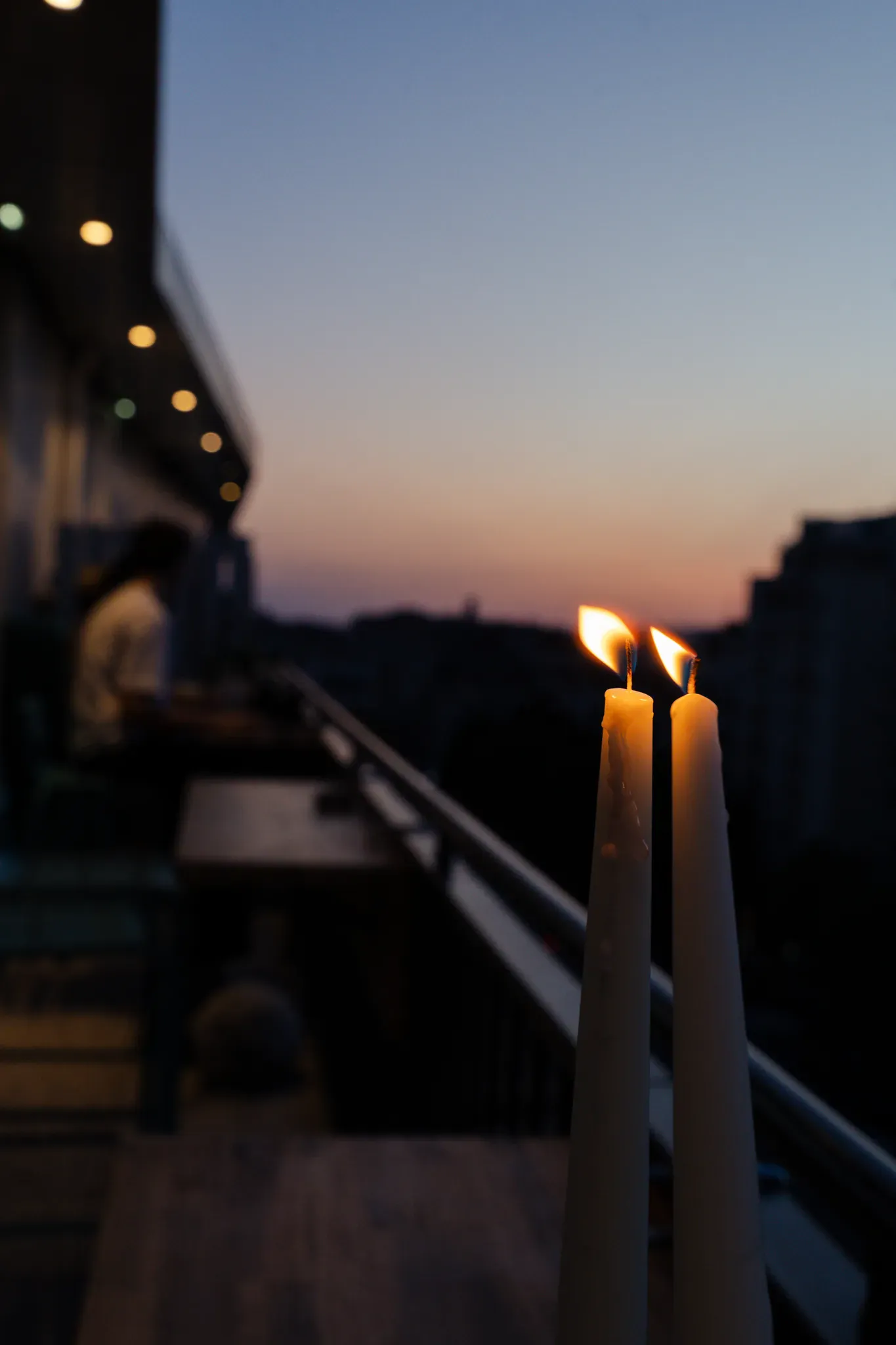 Bougies allumées sur la rambarde de la terrasse au crépuscule