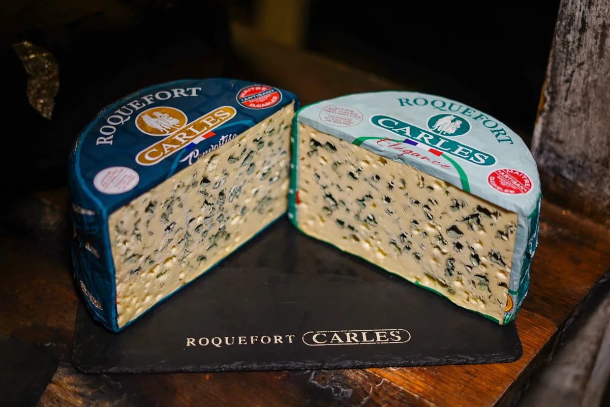 Deux moitiés de Roquefort Carles de la gamme Élégance présentées sur une ardoise gravée