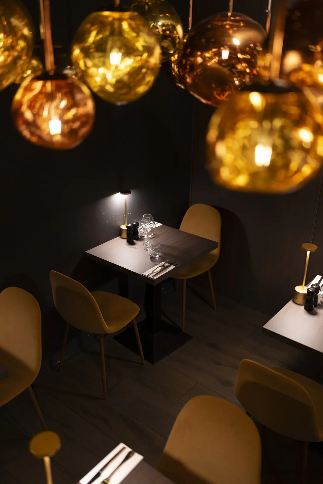 Tables dressées sous les suspensions dorées