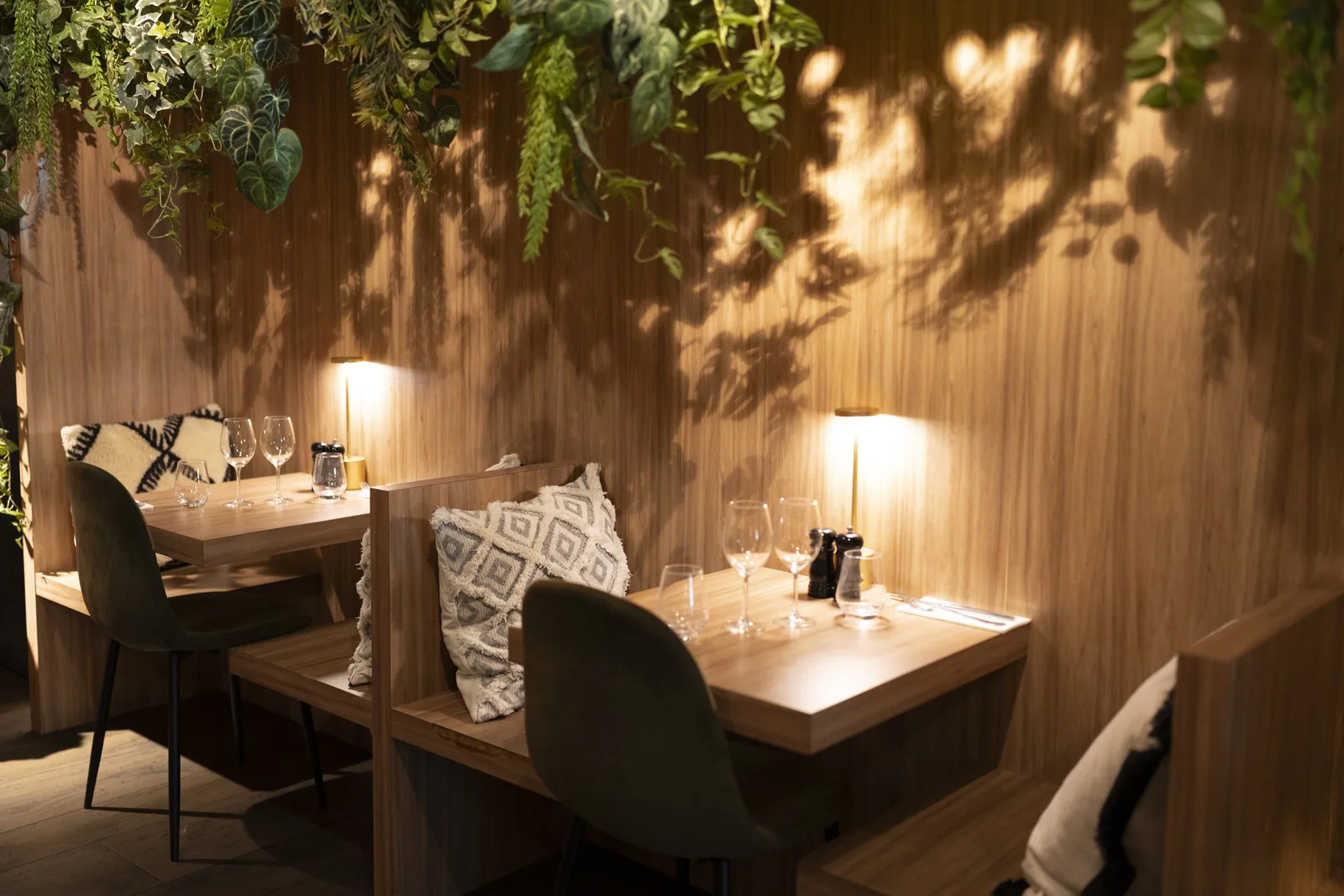 Banquettes et lampes de table le long du mur végétal