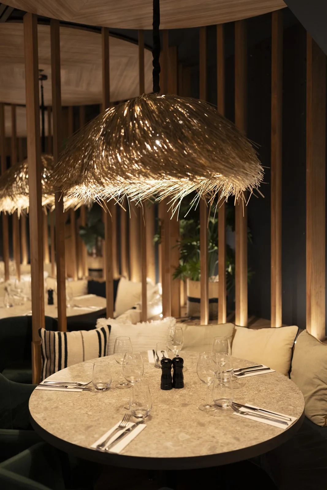Table ronde dressée sous une suspension en paille