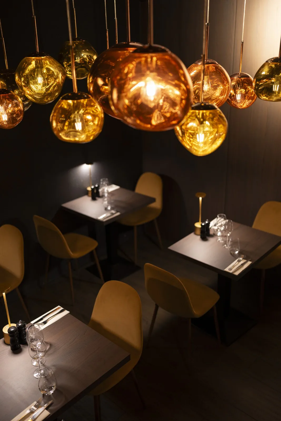 Suspensions dorées au-dessus des tables