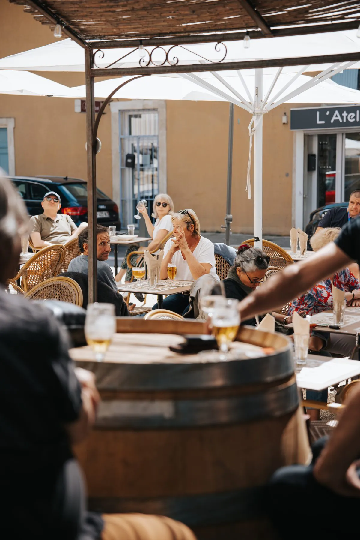 La terrasse pleine sous les parasols, bières et conversations sur le cours de Mornas