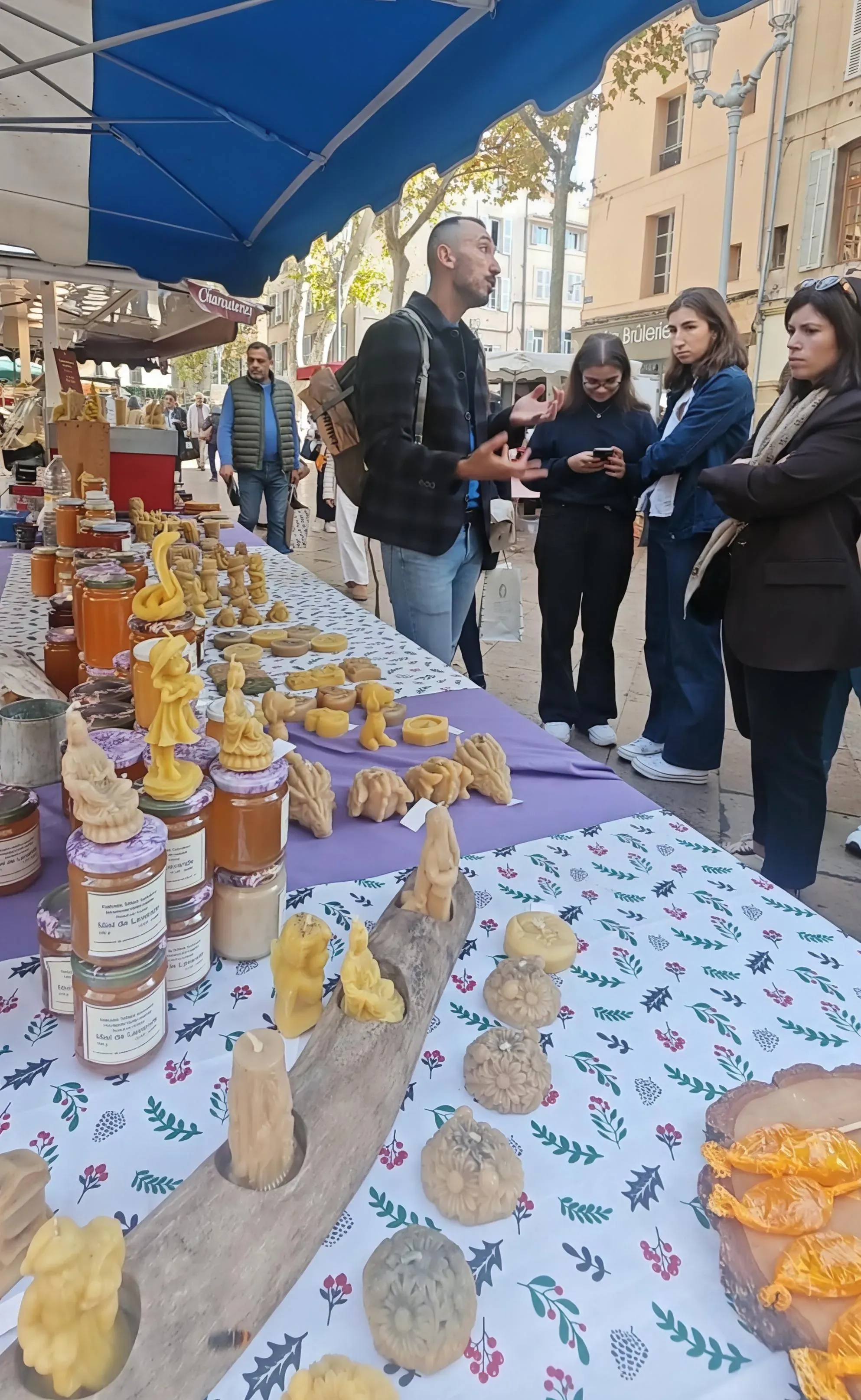 Etal d'un artisan presentant miel et produits a la cire d'abeille sur le marche