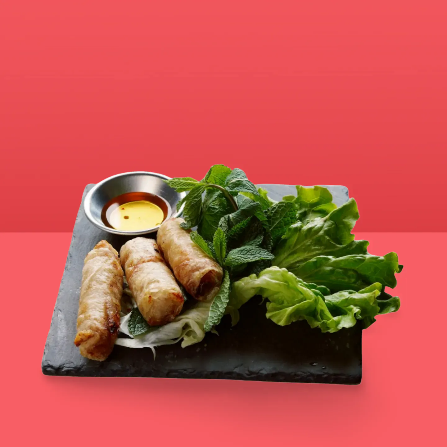 Nems croustillants servis avec salade et menthe, un plat asiatique facile à emporter