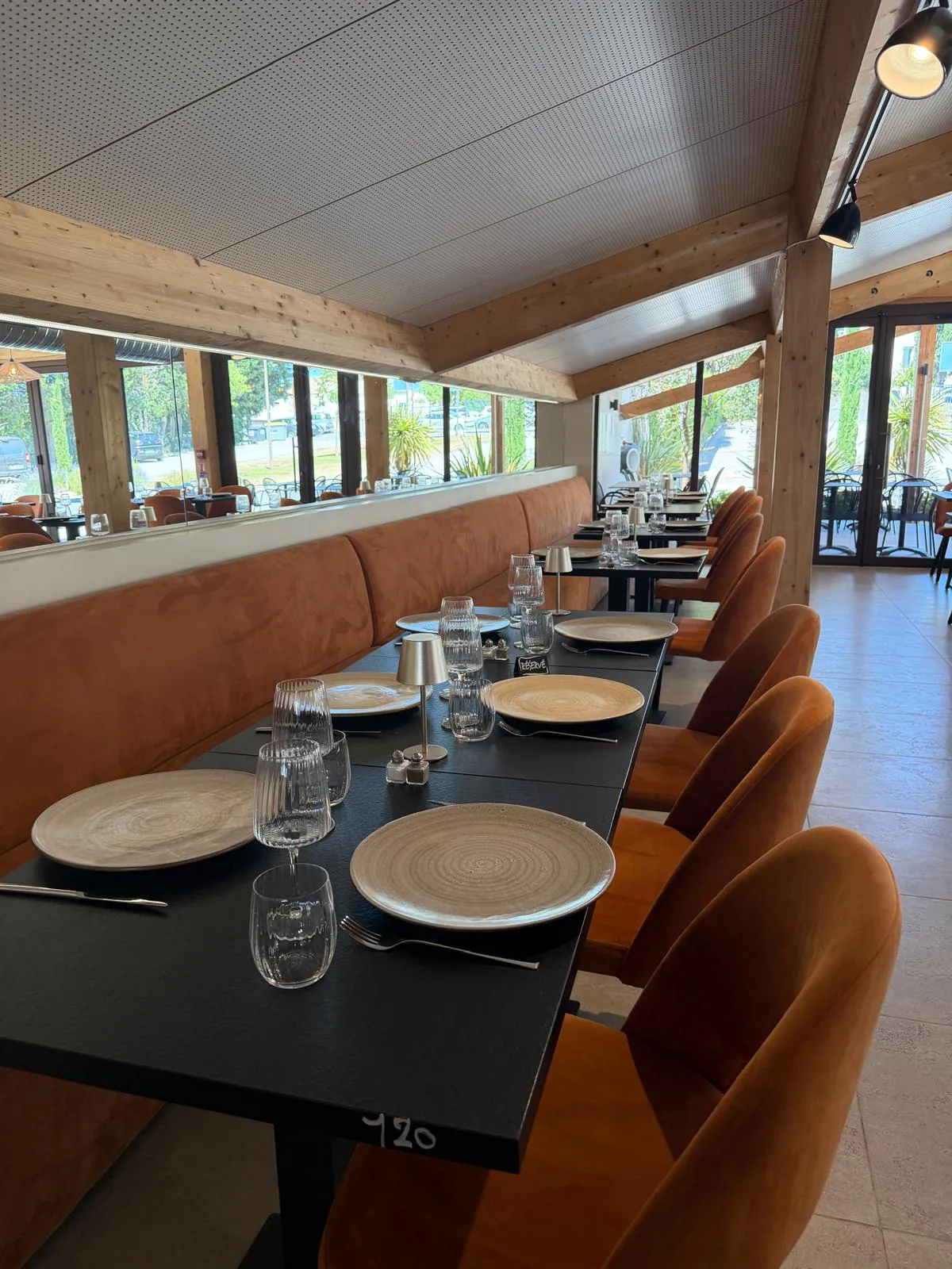 Salle du restaurant Pakal aux tables noires dressées et banquettes de velours orange, ambiance de brasserie contemporaine à Bouc-Bel-Air.