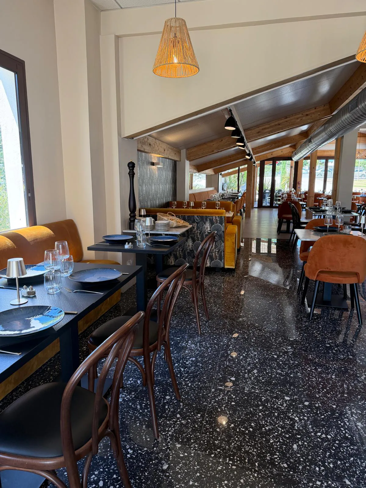 Interior of Pakal restaurant with mustard velvet banquettes and terrazzo floor, minutes from Luynes.