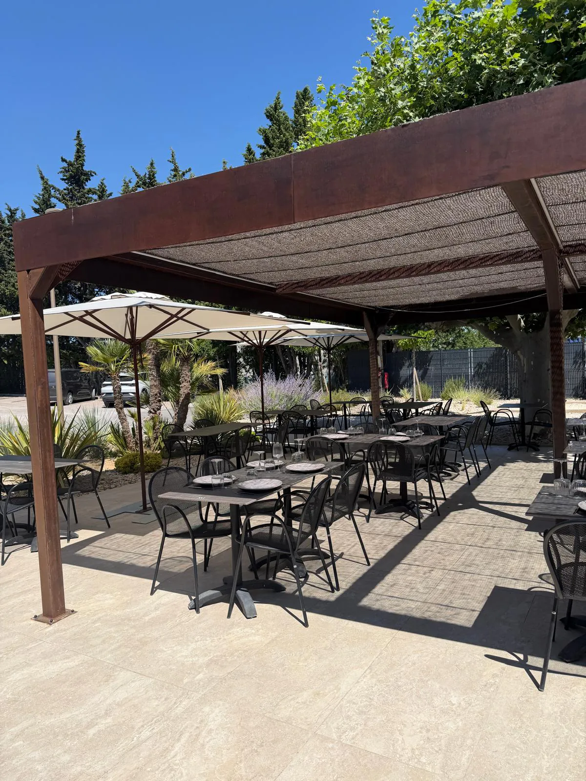 Terrasse extérieure du restaurant Pakal avec tables dressées et parasols, idéale pour un repas convivial à Bouc-Bel-Air.
