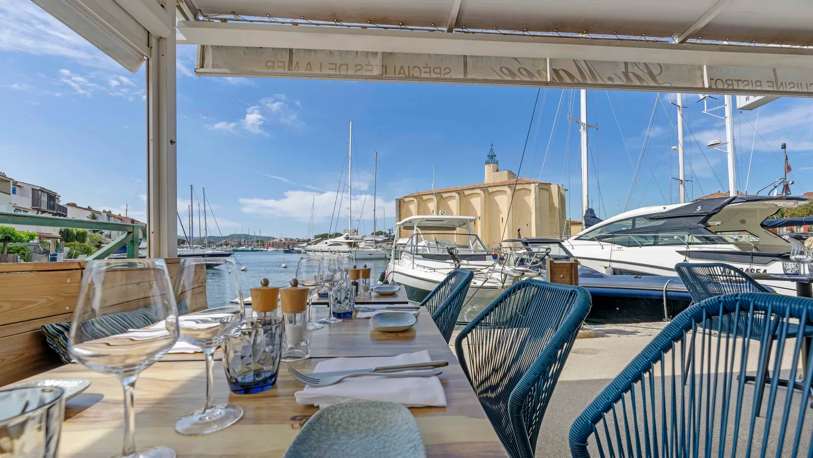 Vue depuis la terrasse du restaurant La Marée à Port Grimaud, bateaux du port et église Saint-François-d'Assise en arrière-plan
