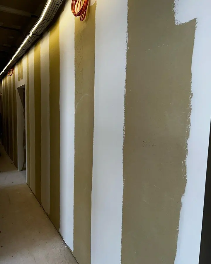 Couloir de chantier bordé de cloisons en plaques de plâtre séparant les pièces