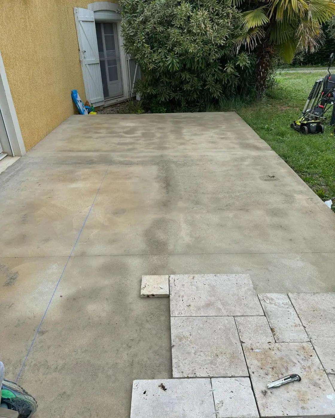 Pendant : Terrasse en cours de pose de dalles en travertin