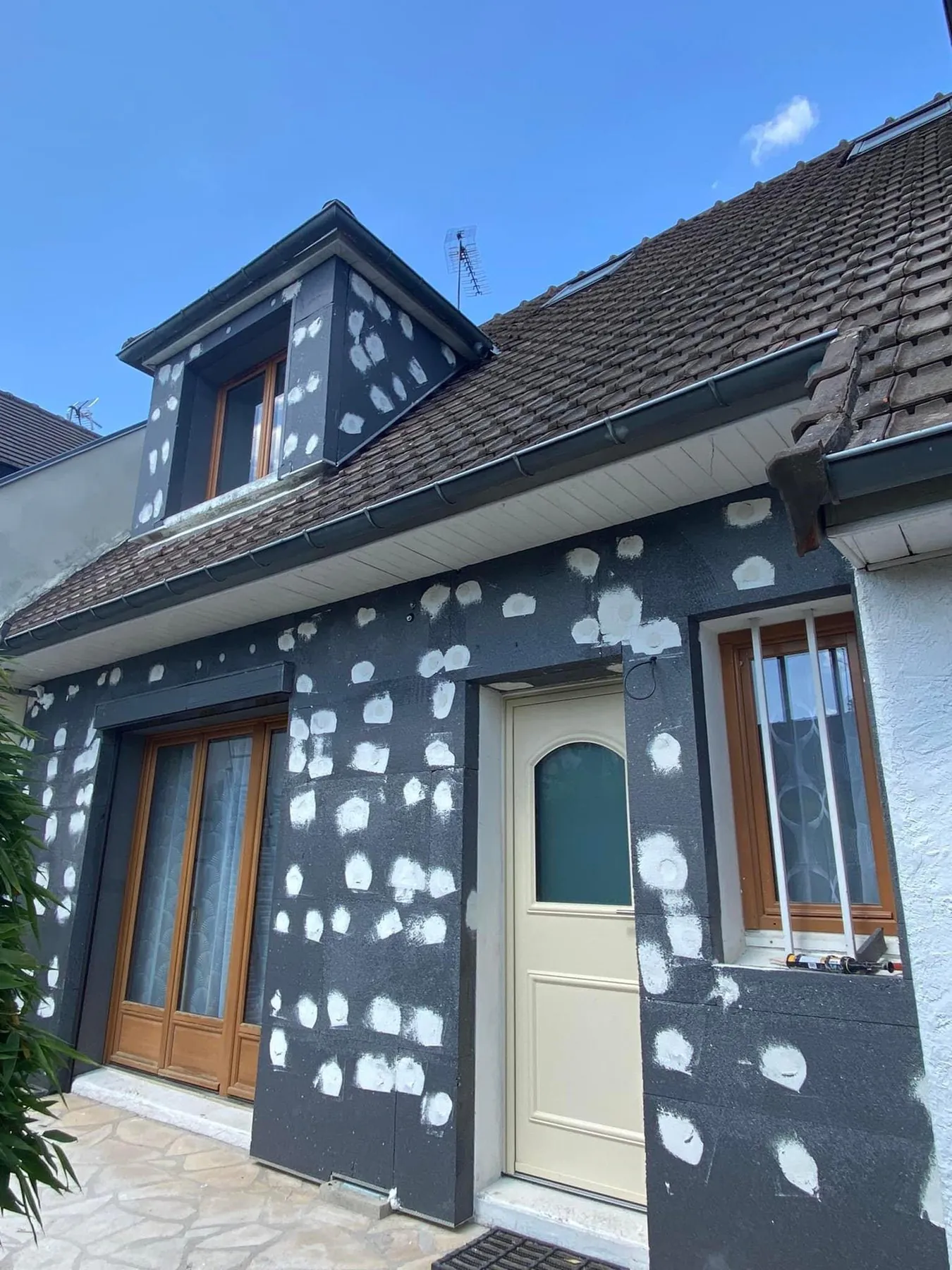 Avant : Façade de maison avant l'enduit, reprises en cours sur le mur