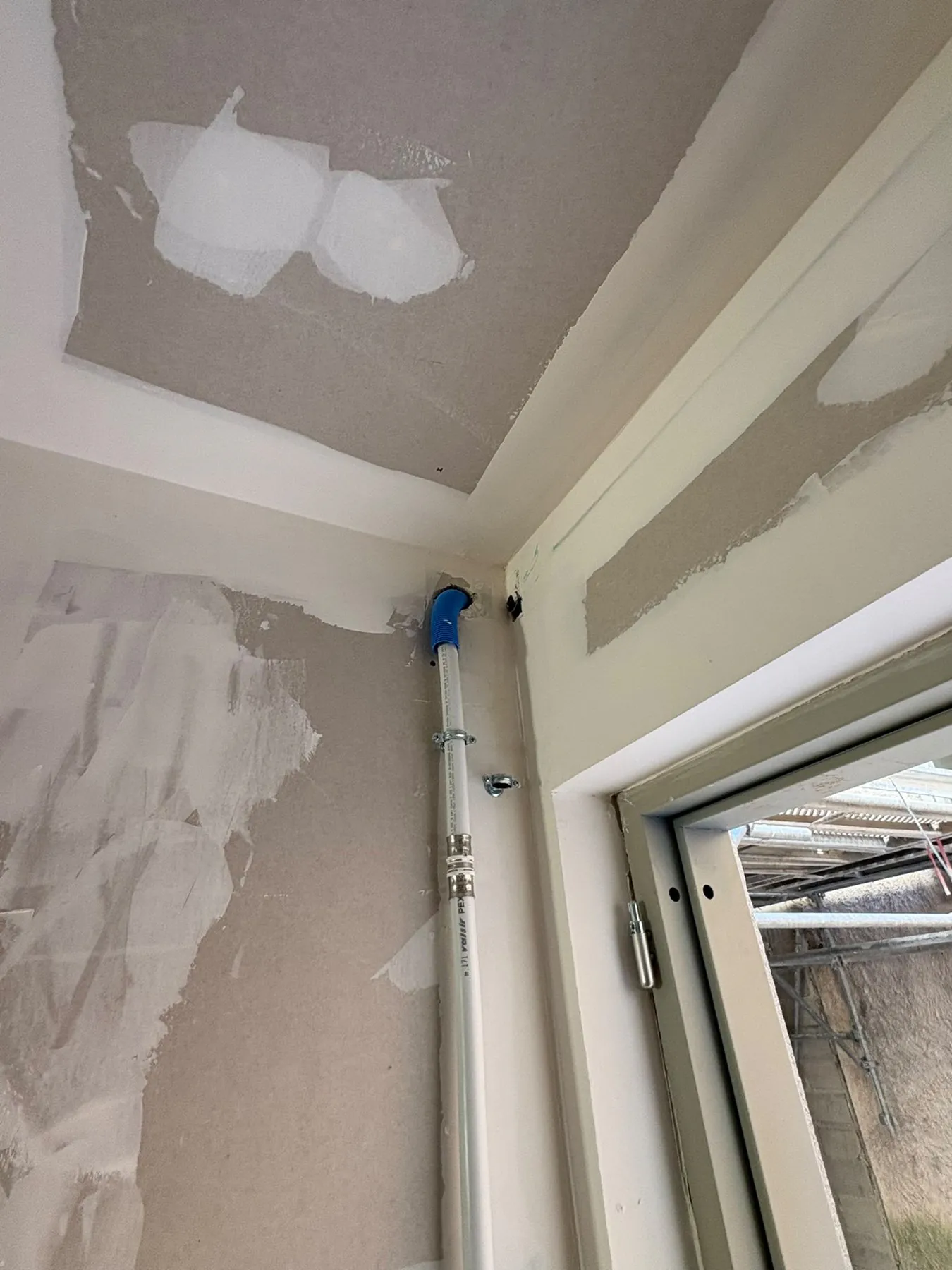 Mur et plafond enduits près d'une fenêtre, avant peinture
