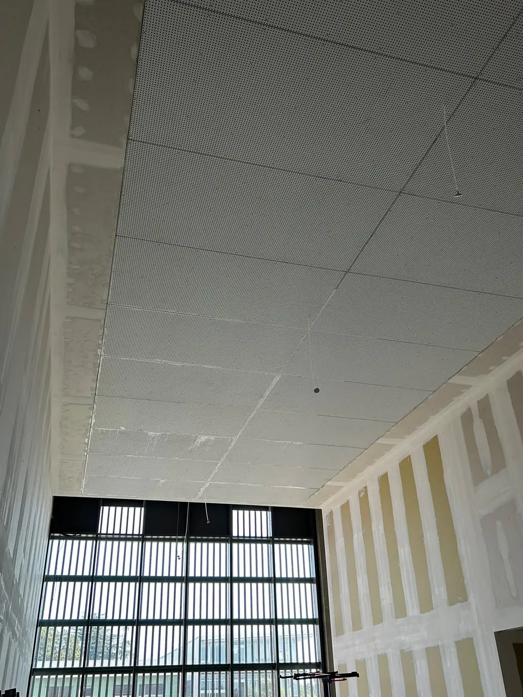 Hall de bâtiment tertiaire : plafond acoustique et grande baie vitrée