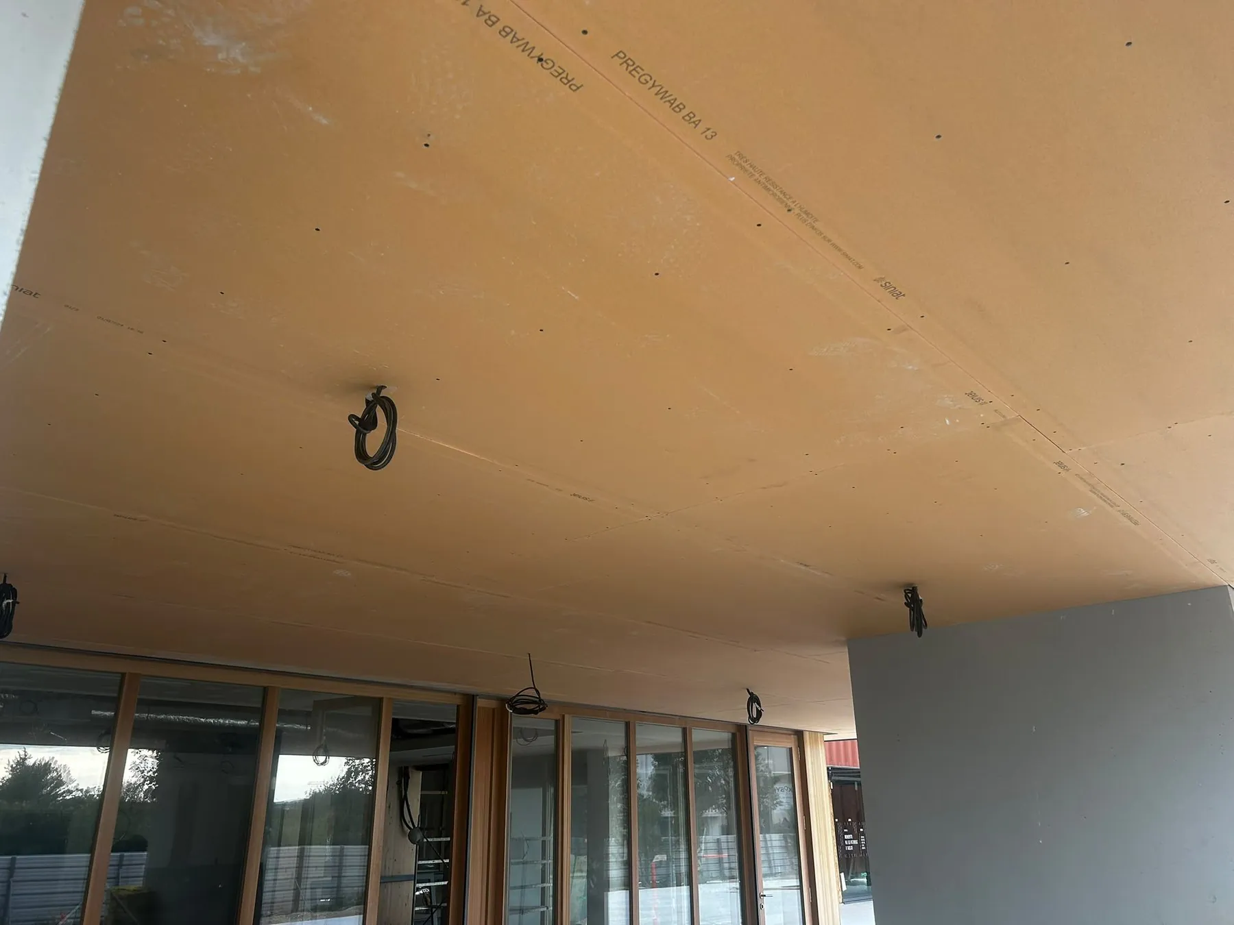 Sous-face en plaques au-dessus d'une baie vitrée