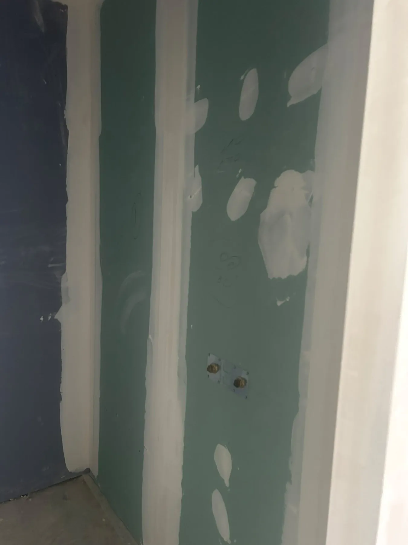 Mur en plaques hydrofuges vertes avec bandes et enduit