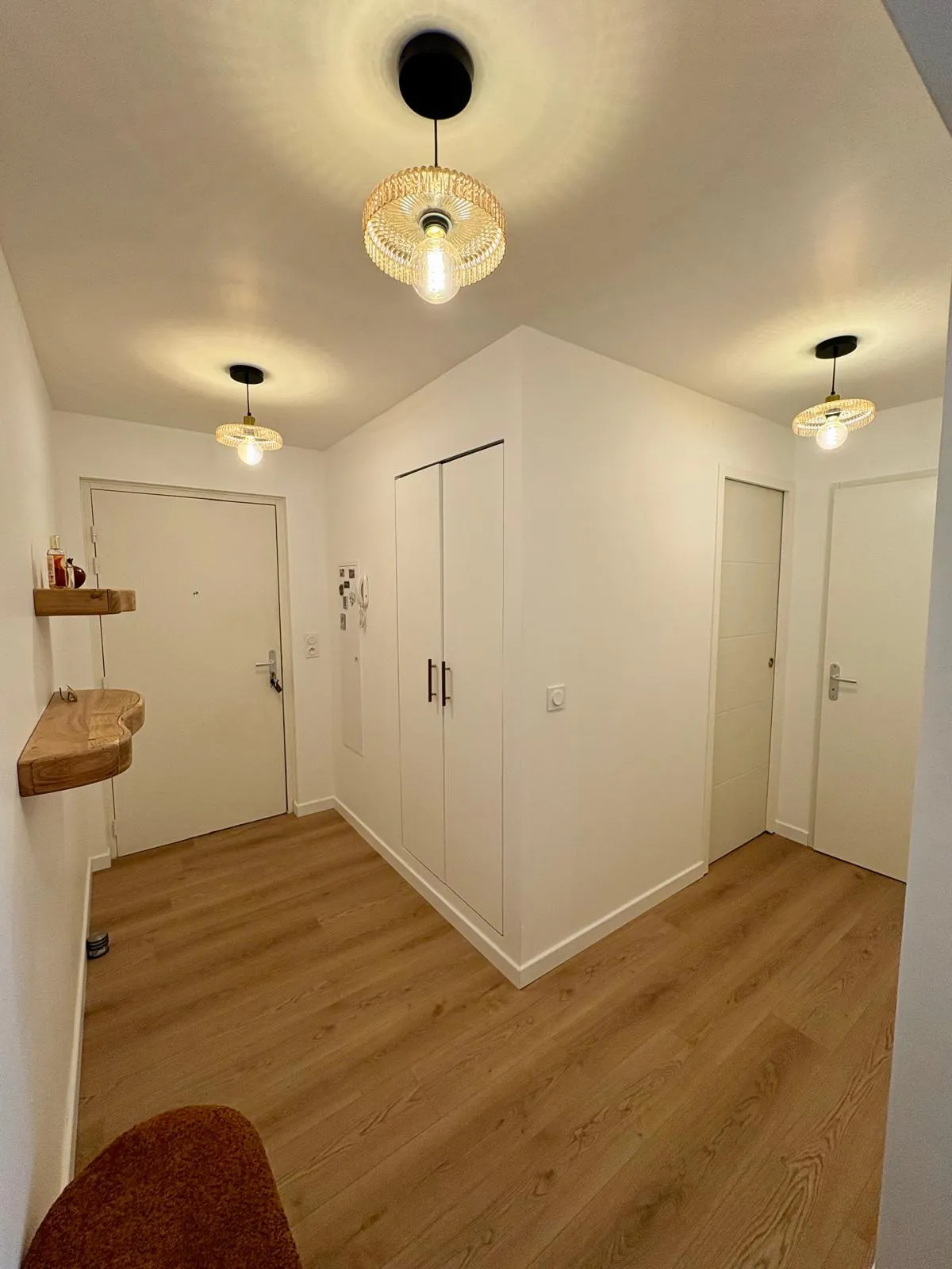 Entrée d'un appartement rénové, suspensions et placards